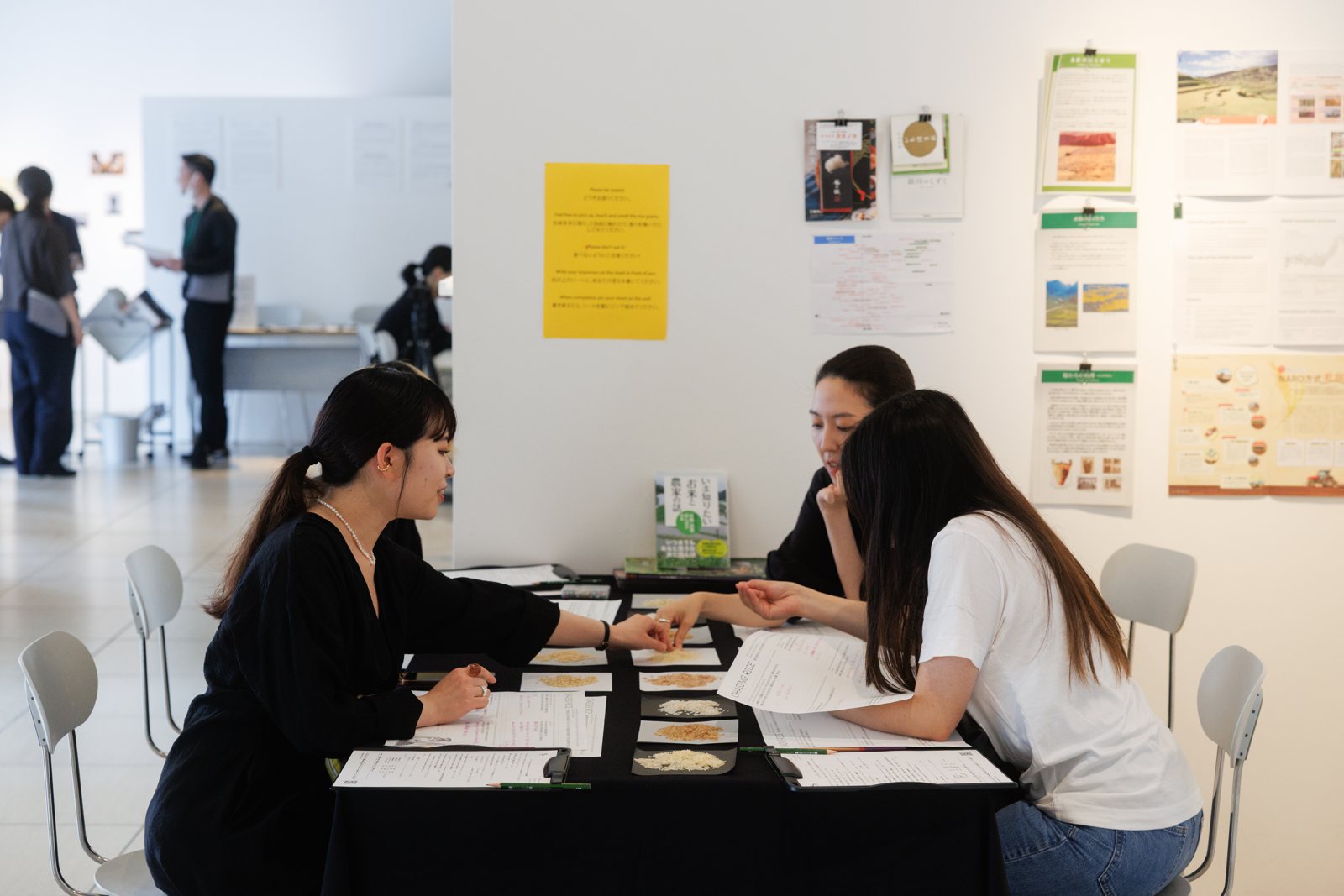 Two visitors writing at the dining table