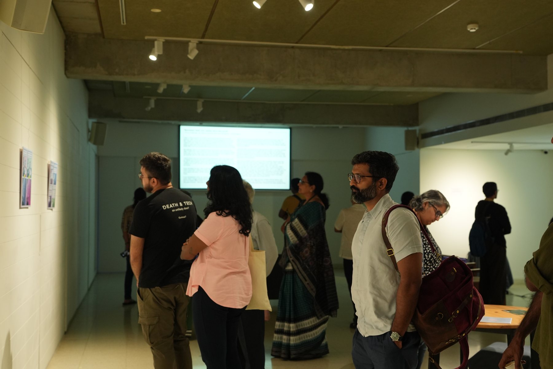 Visitors in the gallery watching a screen