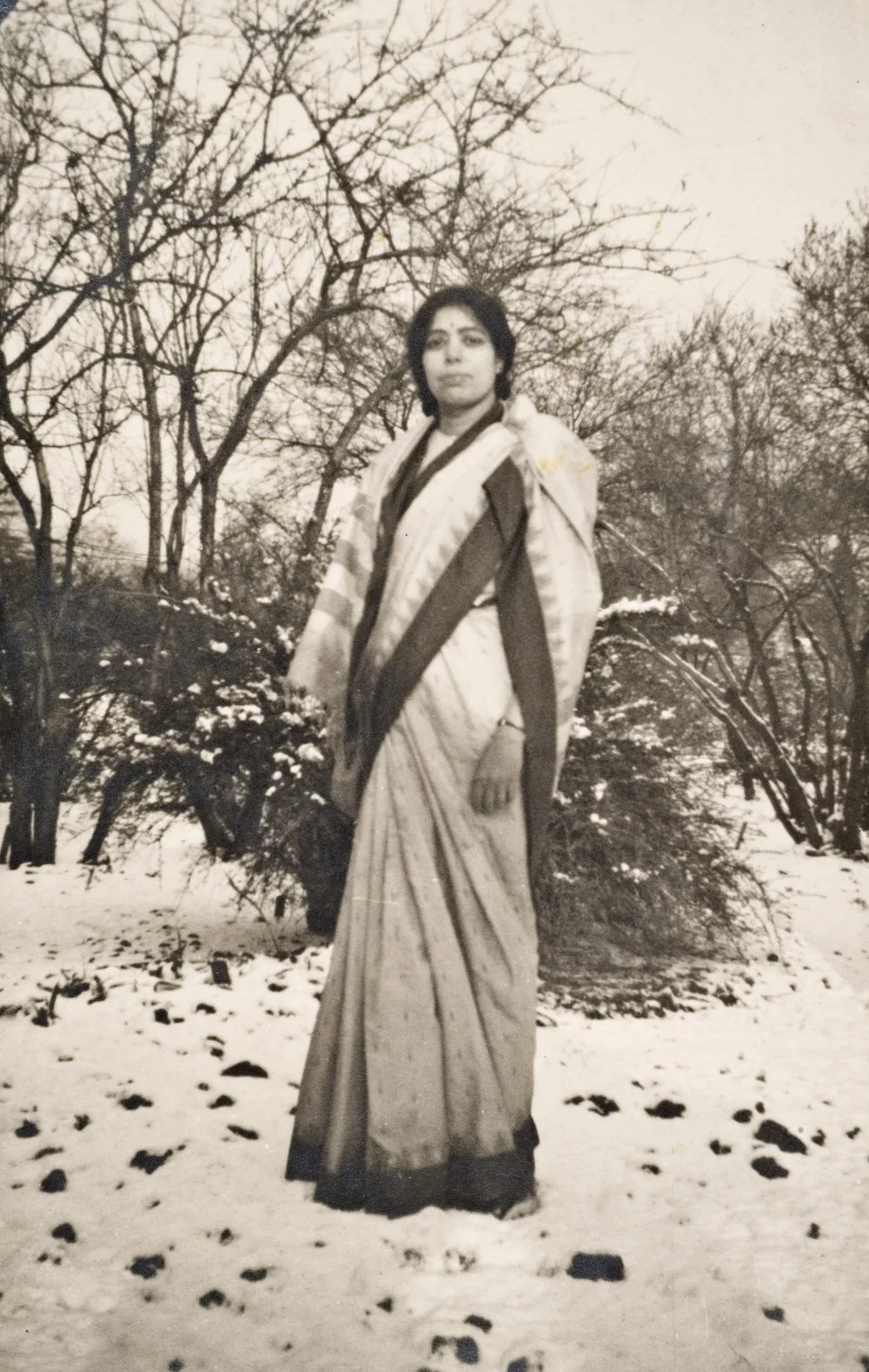 Archival photograph of a woman in a sari in snow