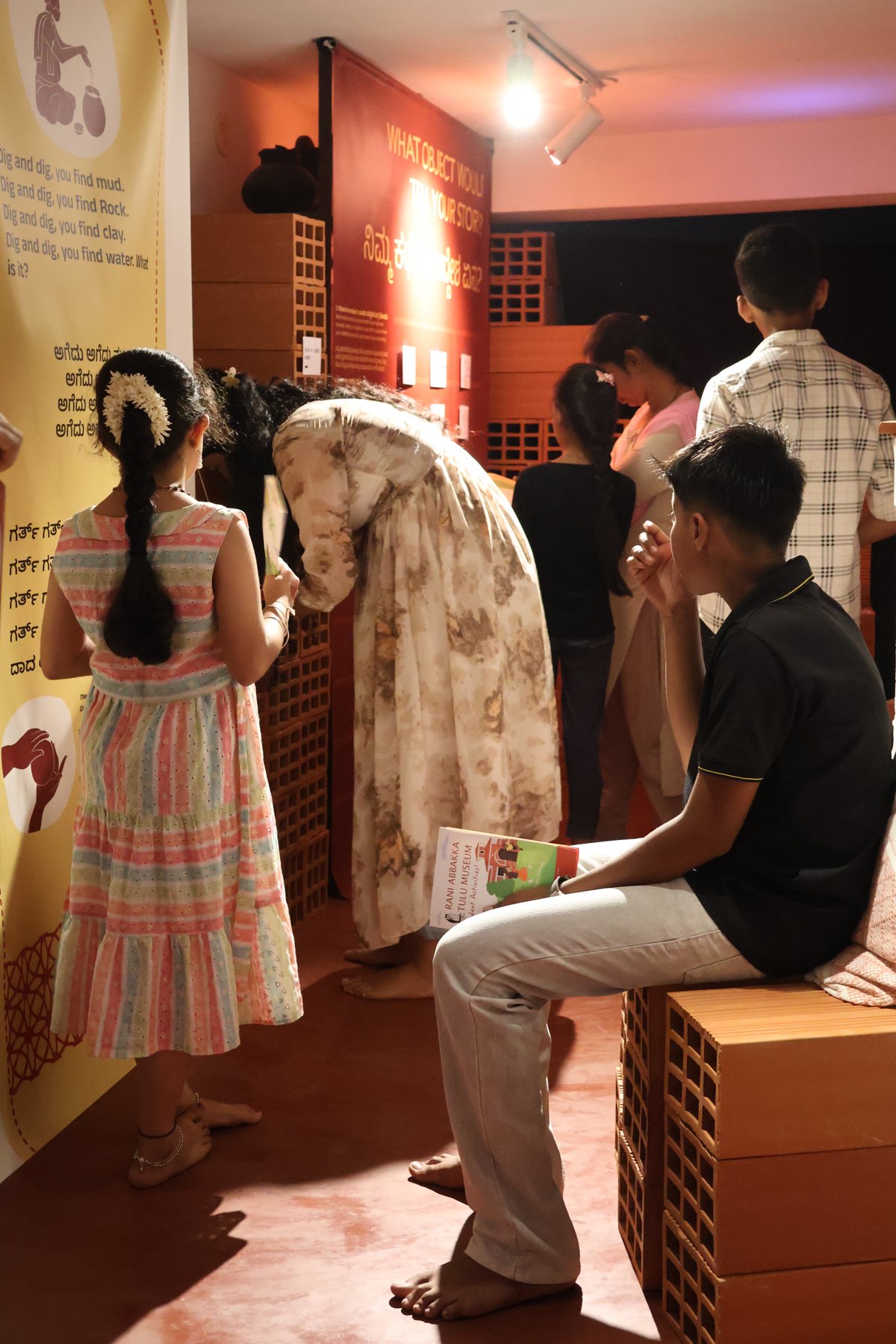 Visitors among the terracotta-brick plinths at Beneath the Green Canopy