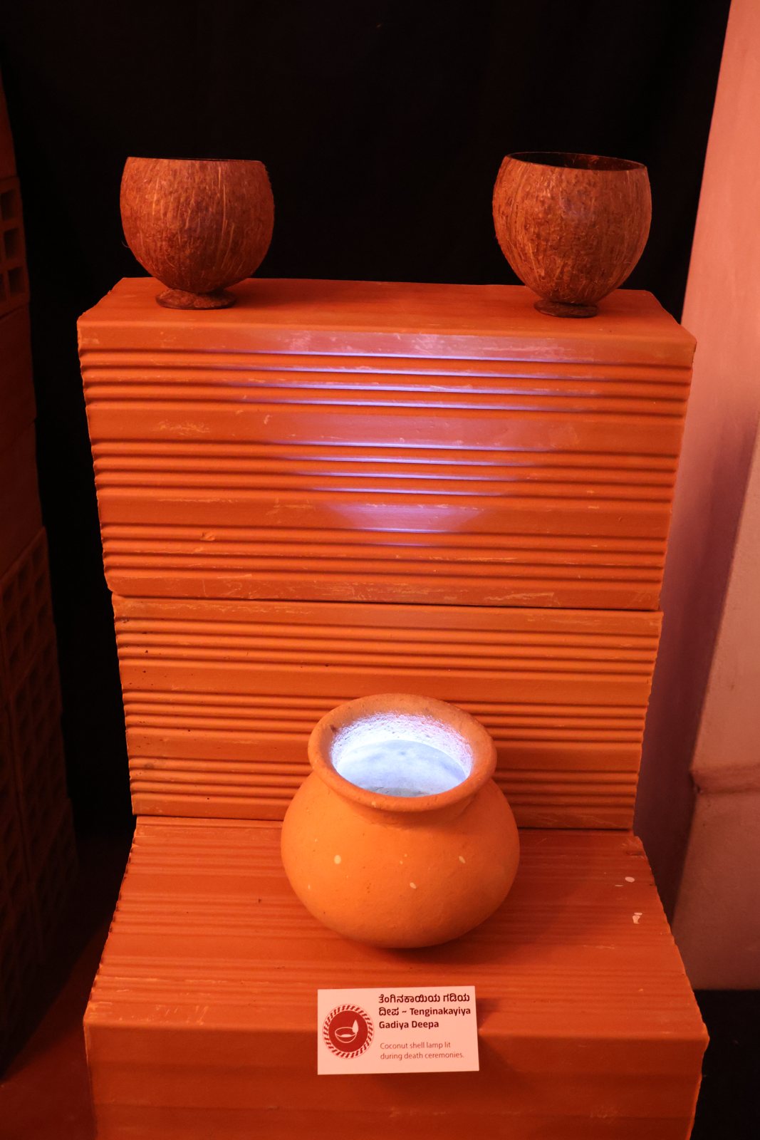 A clay pot displayed on an orange plinth
