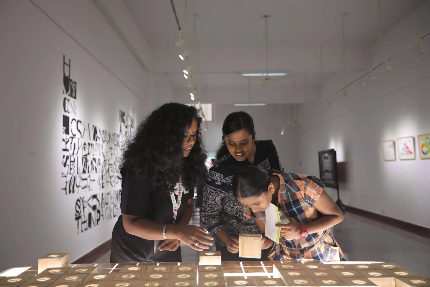 Visitors examining objects on a lit table