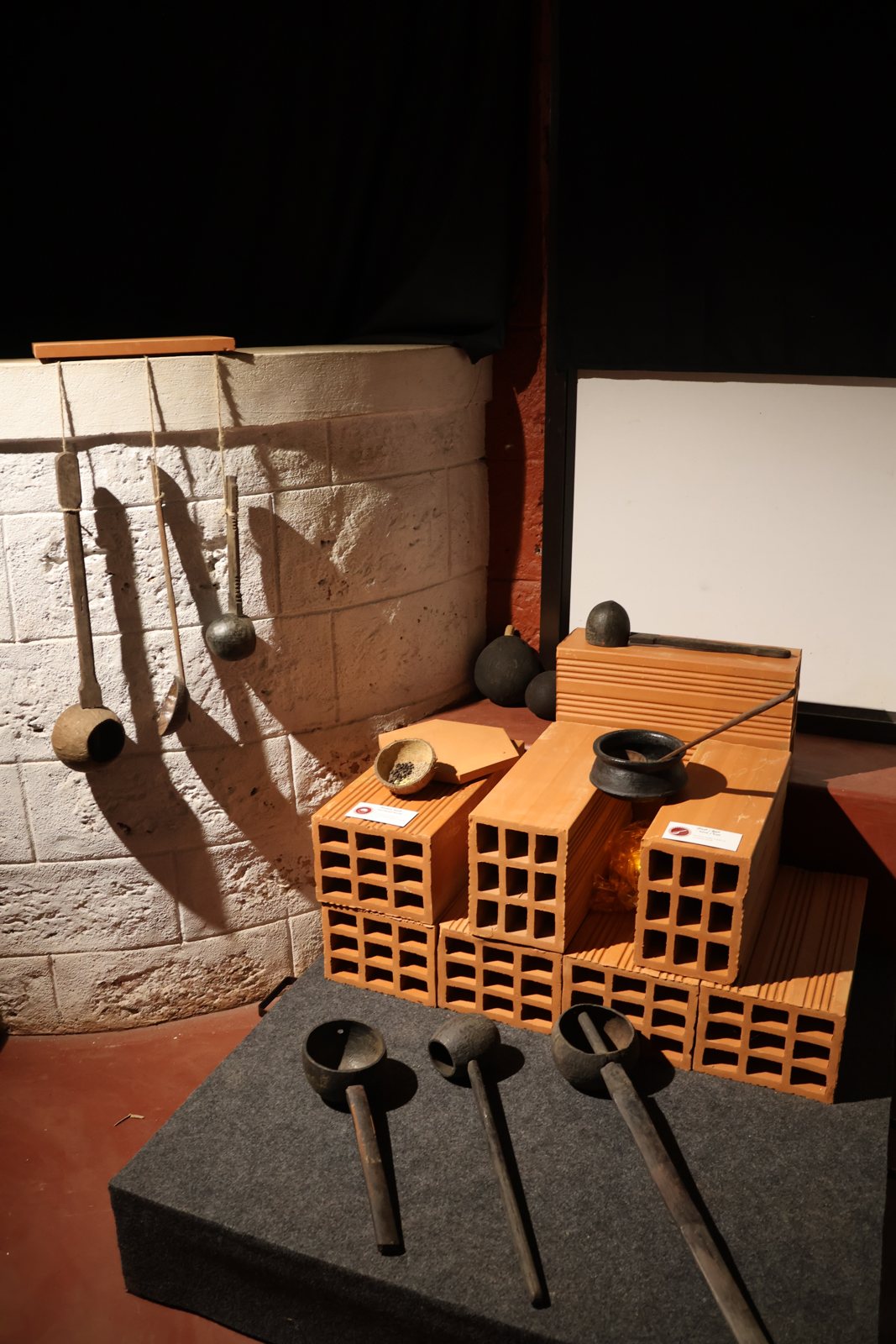 Objects on terracotta-brick plinths