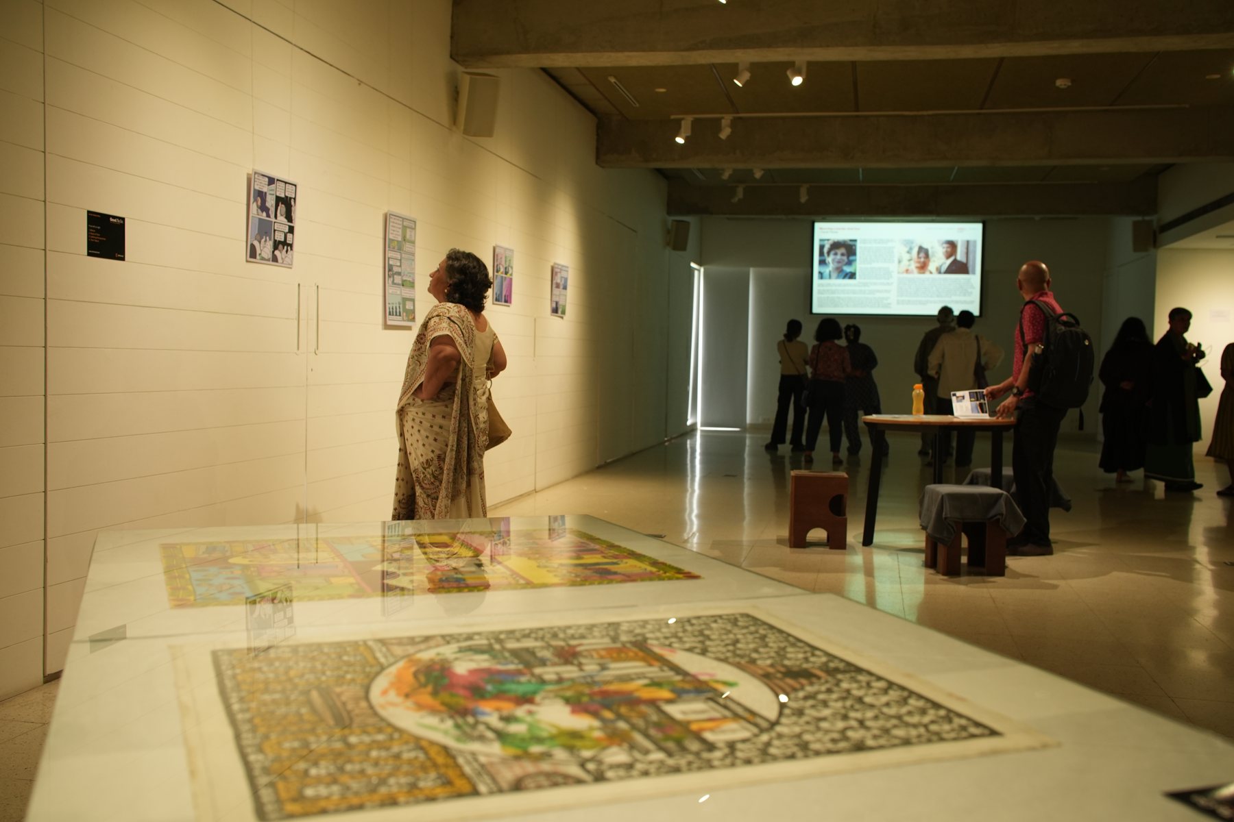 Visitors in the gallery around a large floor artwork