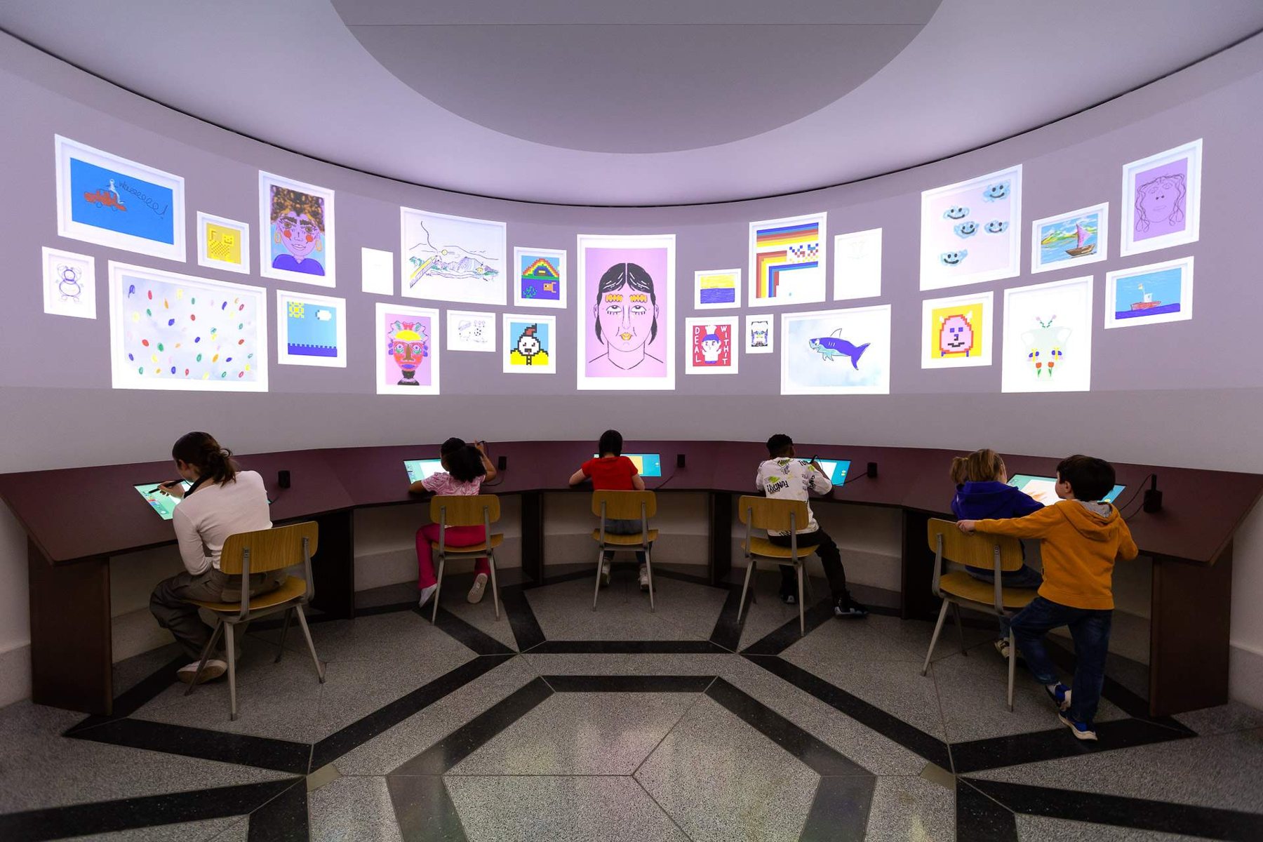 A circular gallery lined with screens showing visitors' drawings