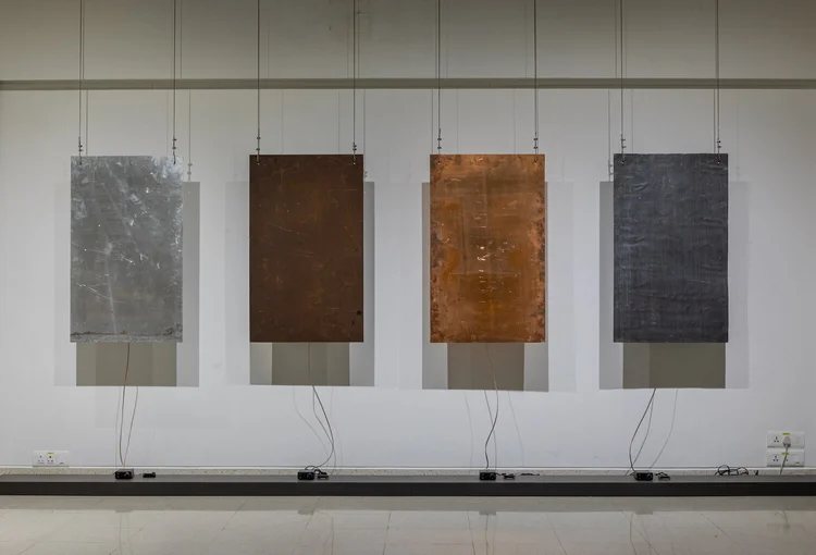 Four textured panels on a gallery wall