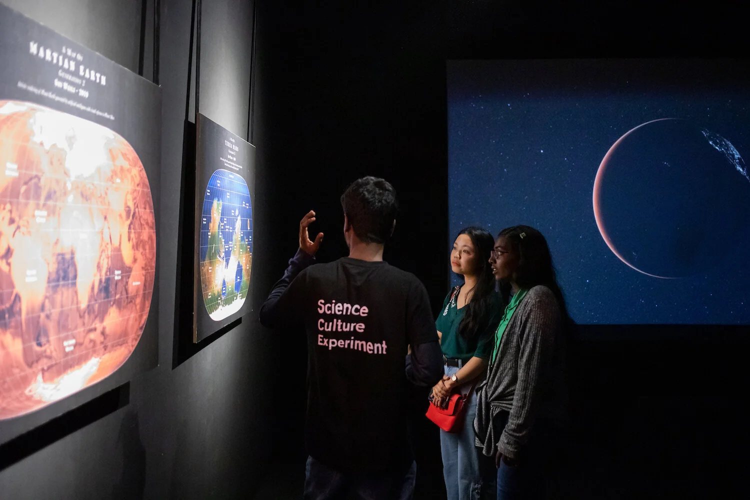 Visitors in front of large planetary images