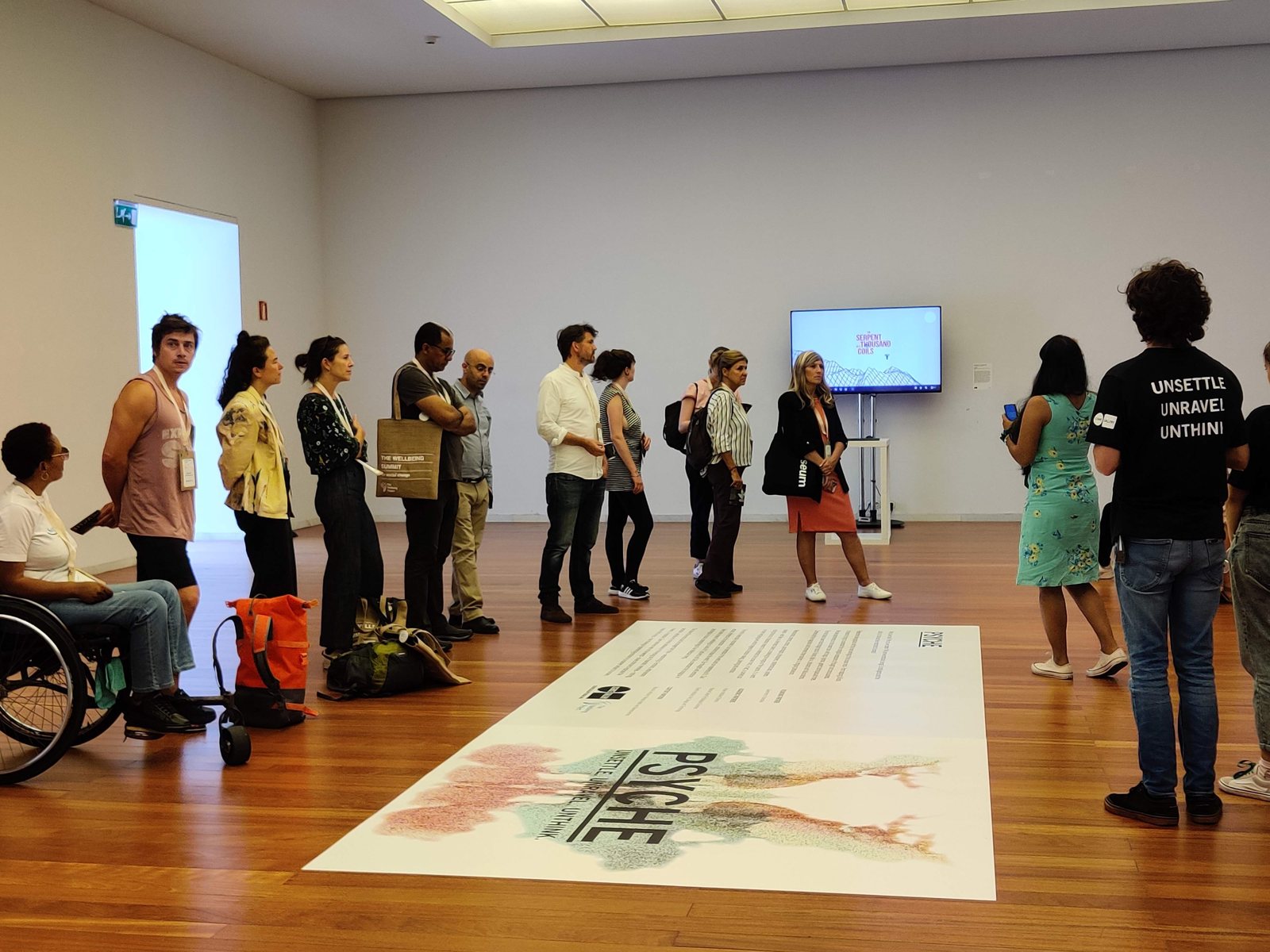 Visitors gathered around a floor graphic in a gallery